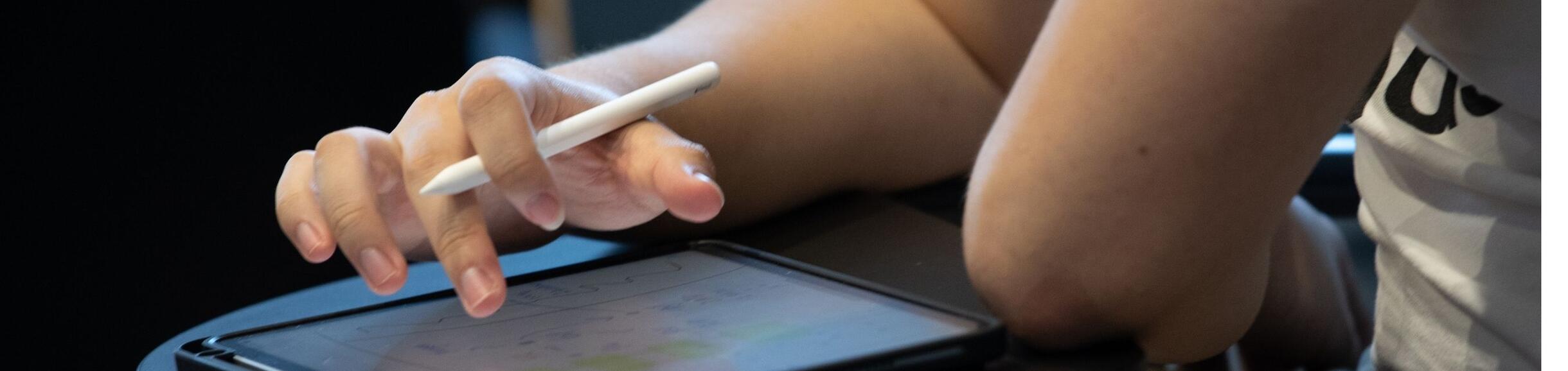 hand taps computer screen and holds a pen