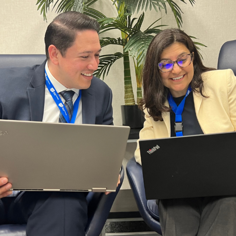 Two staff members on laptops in ITS lounge