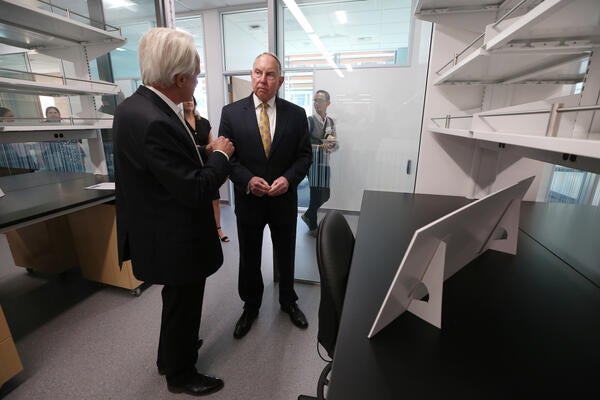 men in suits access an empty office desk