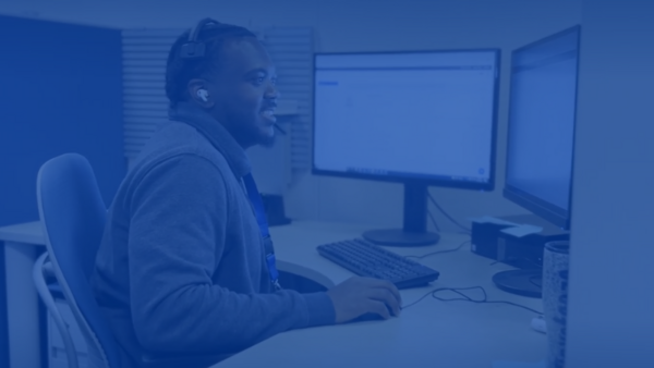 Call Technician wearing a headset sitting by computer