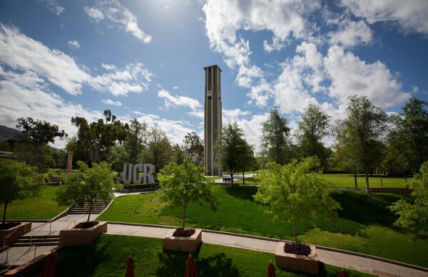 cloudy blue skies over the UCR sign and clock tower