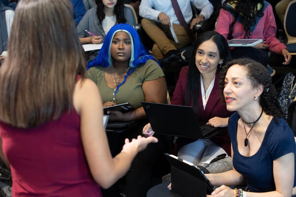 Three students consulting with a professor