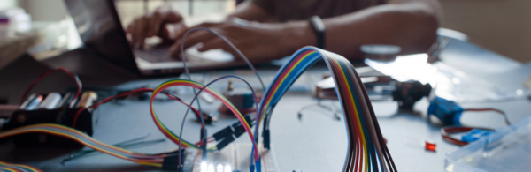 hardware wires and hands over a laptop computer