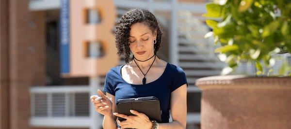 Woman stands with tablet 