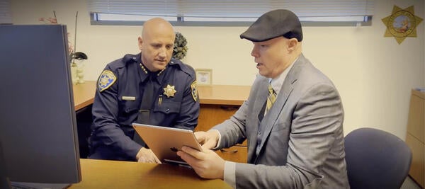 Police officer & ITS worker look at tablet