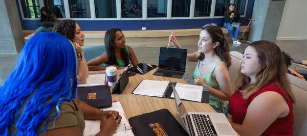 5 students sit with technology 