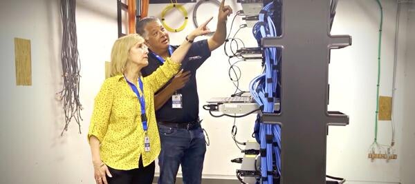 networking technicians point at wires in networking room