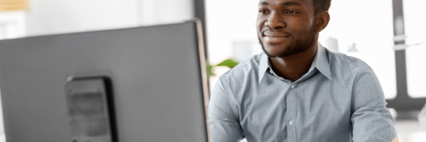 man looks at screen smiling