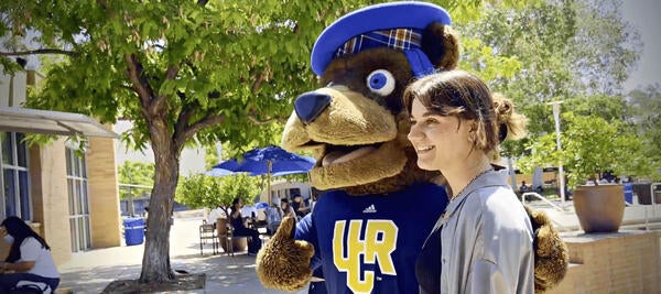 Scotty bear mascot and student