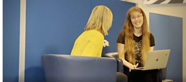 Two ITS employees talk with a laptop