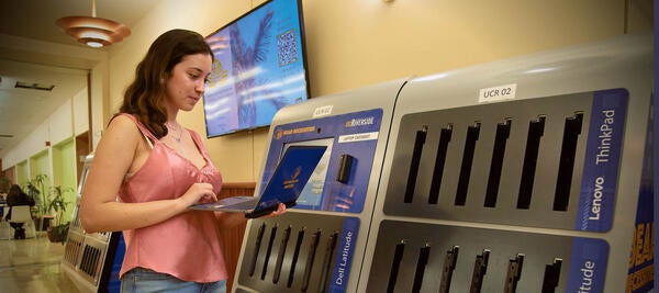 student checks out laptop from library kiosk