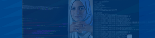 PhD student poses between two computer screens