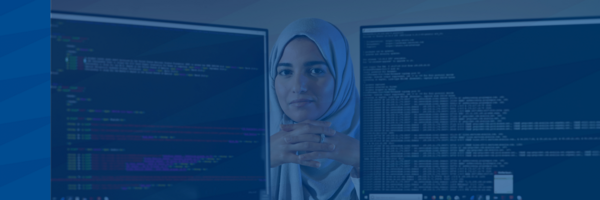 PhD student poses between two computer screens