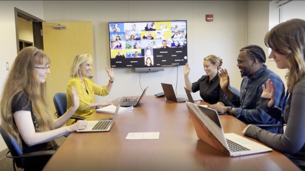 A team sitting in a conference room on their computers