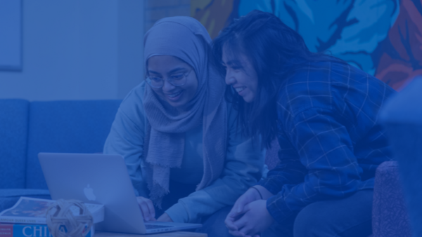 Two students looking over a computer