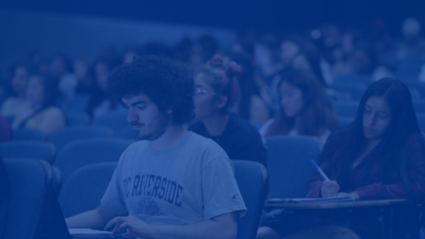 Student typing on laptop during lecture