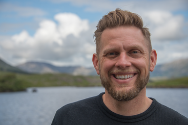 CIO, Matt Gunkel, smiles in front of a lake