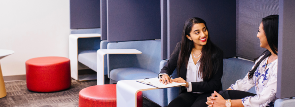 Two staff members sitting and discussing work