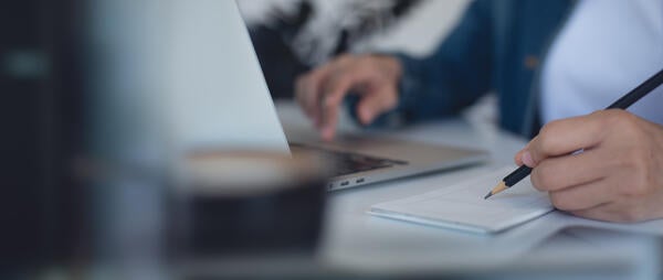 people conducting research using computers and notebooks