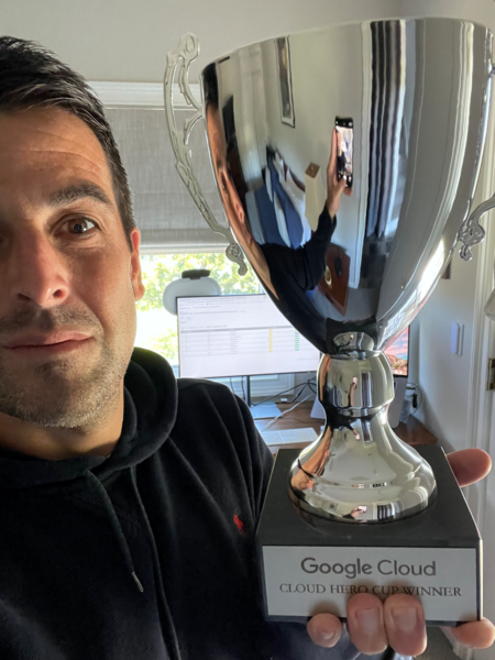 man in a black hoodie holds up trophy