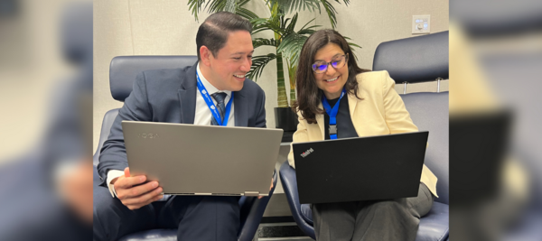 Two staff members on laptops in ITS lounge