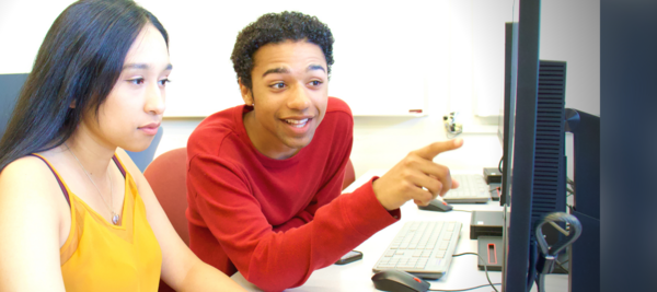 Excited student points at computer monitor