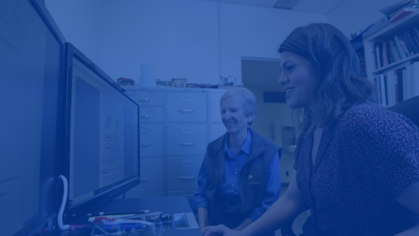 Two women faculty looking at a computer