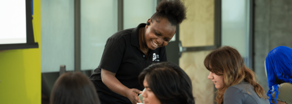 staff member helps other students in classroom