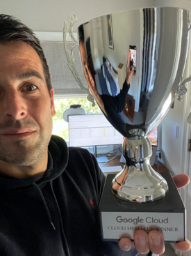 man holds silver Google trophy