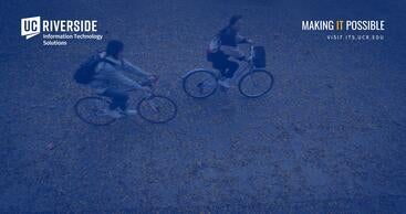 Two students riding bikes through the fall leaves